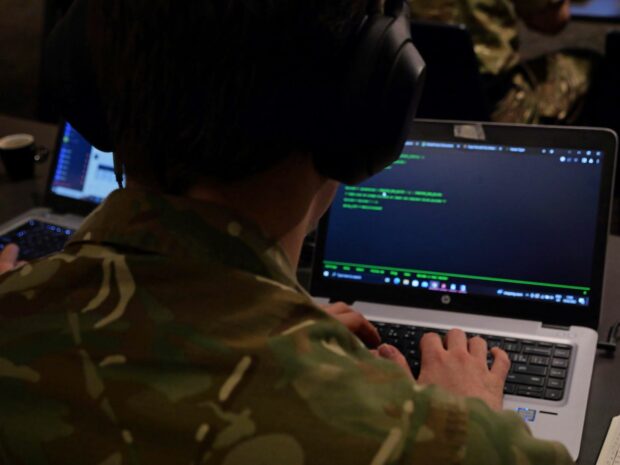 Individual looking computer screen.